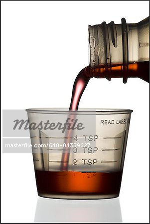 Syrup being poured into a plastic measuring cup