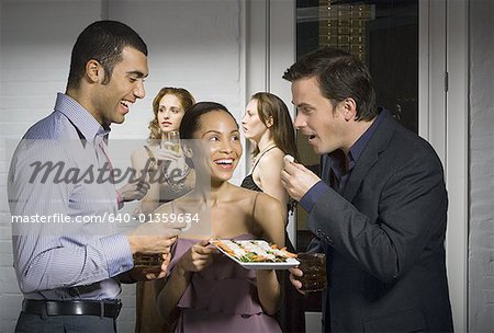 Two men enjoying an appetizer at a party