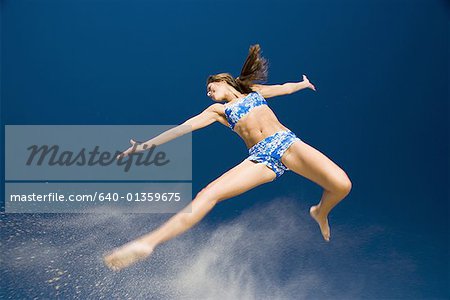 Vue d'angle faible d'une jeune femme sautant