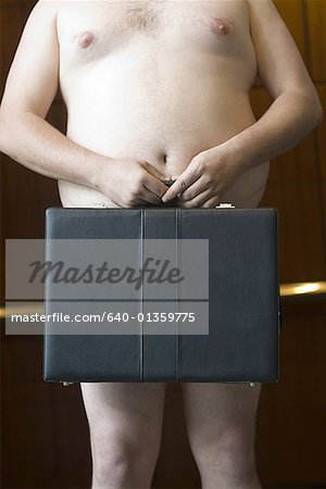 Mid section view of a naked businessman holding a briefcase