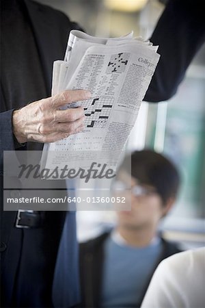 Milieu vue en coupe d'une personne tenant un journal dans un train de banlieue
