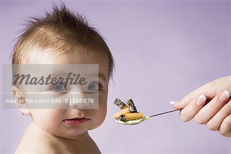 Bébé avec une cuillère pleine de mégots de cigarettes