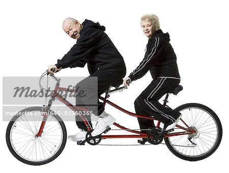 Older couple riding a tandem bicycle