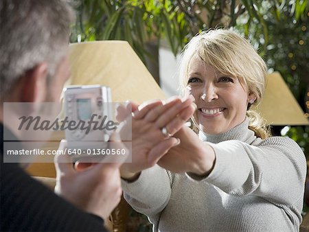 Rear view of a man trying to take a woman's photograph