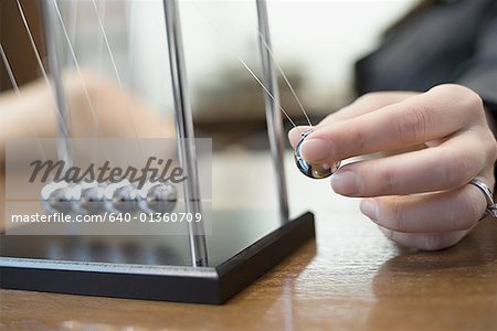 Close-up of a person's hand holding a pendulum