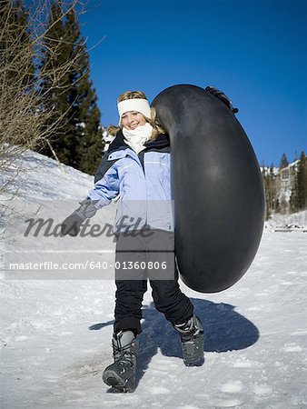 Low angle view of a girl running with an inner tube
