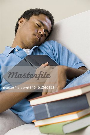 Teenage boy sleeping with a book on his chest