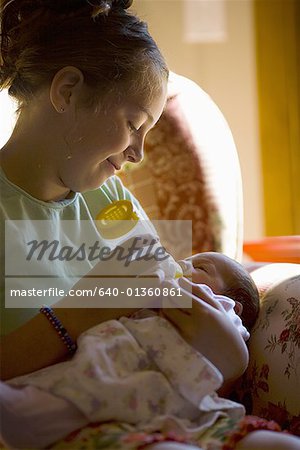 Mother feeding her baby girl a bottle of milk