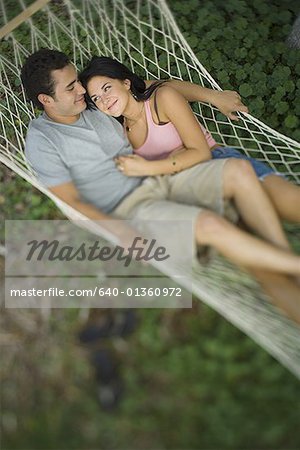 High angle view of a young couple lying on a hammock