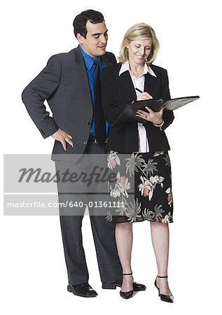 Businesswoman writing in a folder next to a businessman