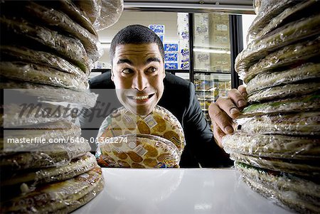 Homme tenant des pizzas à l'épicerie