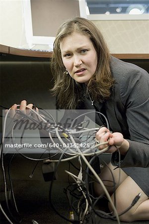 Portrait of a businesswoman holding tangled wires