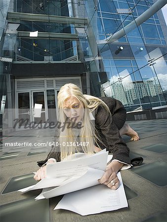 Femme d'affaires ramasser les papiers du sol