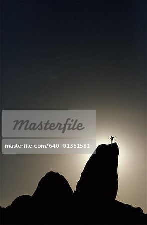 Low angle view of a silhouette of a person standing on a mountain peak