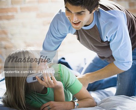 Young man bending over a young woman lying on a bed
