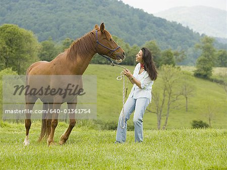 Frau hält die Zügel eines Pferdes