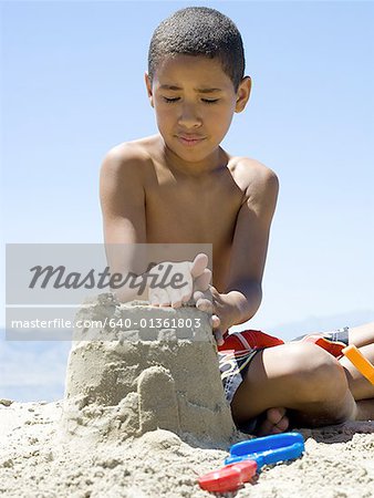 Gros plan d'un garçon faire un château de sable