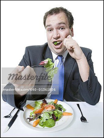 Portrait of a young man eating a vegetable salad