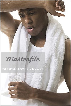 Close-up of a young man wiping sweat with a towel