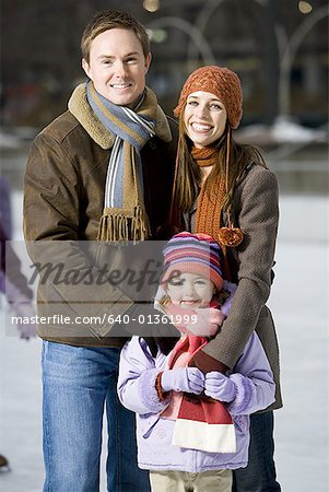 Man and woman with little girl outdoors in winter