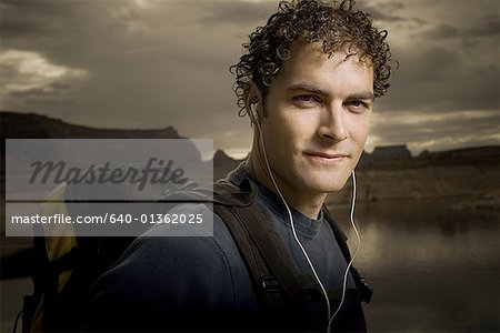 Porträt eines jungen Mannes, das Tragen von Kopfhörern und einem Rucksack