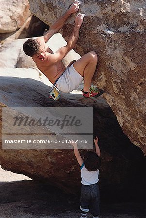 Vue grand angle sur un escalade de l'homme et un enfant atteint par le bas vers le haut