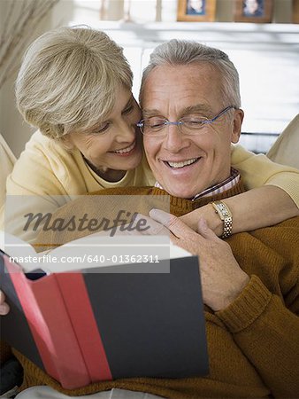 Elderly woman embracing an elderly man from behind