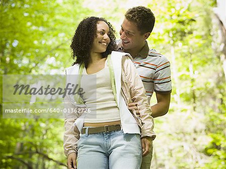 Close-up of a young man embracing a young woman from behind