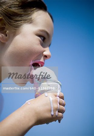 Profile of a girl eating an ice- cream cone