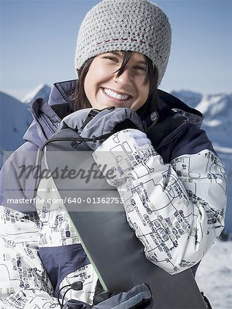 Portrait of a young woman holding a snowboard