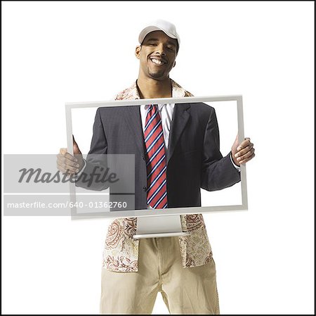 Lässig gekleidete Mann, hält Computermonitor mit Bild von Business-Anzug