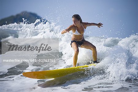 Young woman surfing on a surfboard