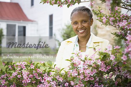Portrait of a mature woman smiling behind flowers