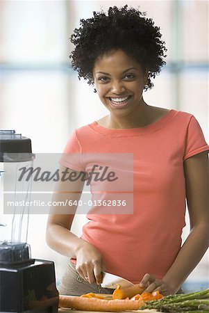 Portrait d'une jeune femme coupe légumes et souriant