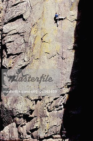 Rear view of a person climbing on a rock