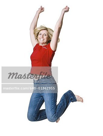 Portrait of a woman jumping with her arms raised