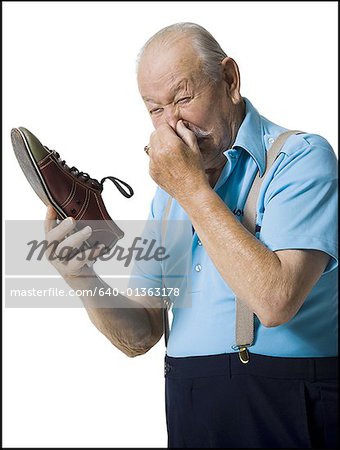 Male bowler sniffing stinky bowling shoes