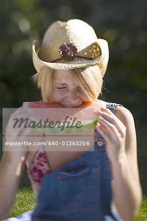 Jeune femme mordre un morceau d'une pastèque