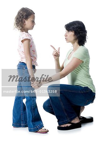 Close-up of a mid adult woman scolding her daughter