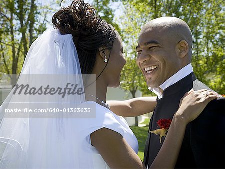 Profile of a newlywed couple smiling together