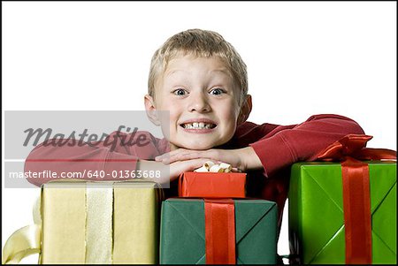 Portrait d'un garçon de se pencher sur la pile de cadeaux