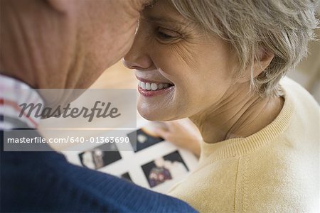 Close-up of an elderly couple smiling and touching heads