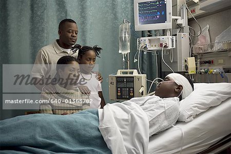Parents et leur fille regardant un adolescent à l'hôpital
