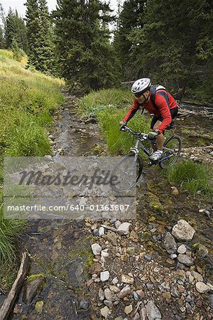 Voir le profil:: un homme d'âge mûr vélo au-dessus d'un ruisseau