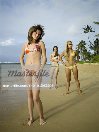 Portrait of three teenage girls standing on the beach
