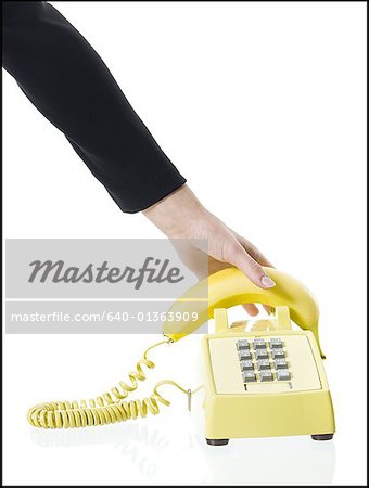 Gros plan de la main d'une personne ramasser un récepteur téléphonique de banane