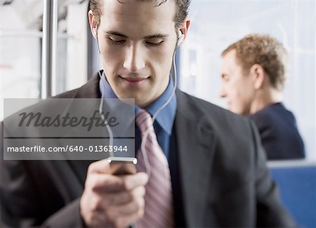 Close-up of a young man using an MP3 player