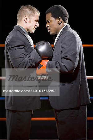 Profile of two businessmen staring at each other in a boxing ring