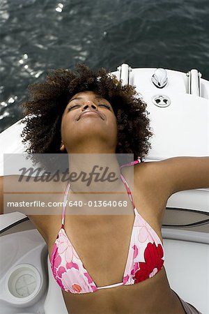 Vue grand angle d'une jeune femme reposant sur un bateau de vitesse