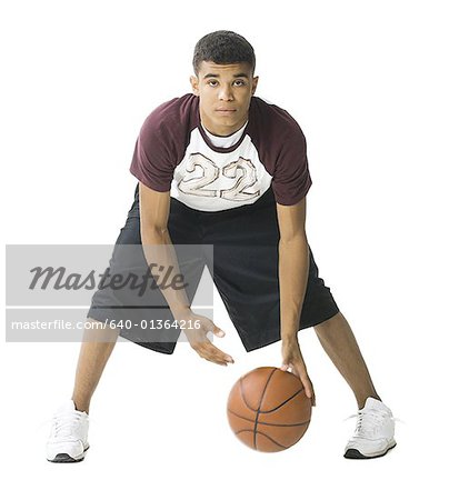 Portrait of a young man playing a basketball